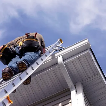 Technician climbing a ladder to repair gutter